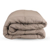 Folded beige comforter with soft quilted design, neatly stacked for display.