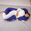 Pregnant woman sleeping comfortably with a U-shaped body pillow in bed.