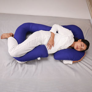 Pregnant woman sleeping comfortably with a U-shaped body pillow in bed.