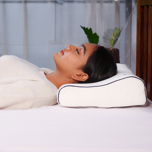 Woman lying on Tencel Memory Foam Cervical Pillow for neck and spine support.