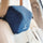 Blue memory foam car neck pillow on beige seat for head and neck support.