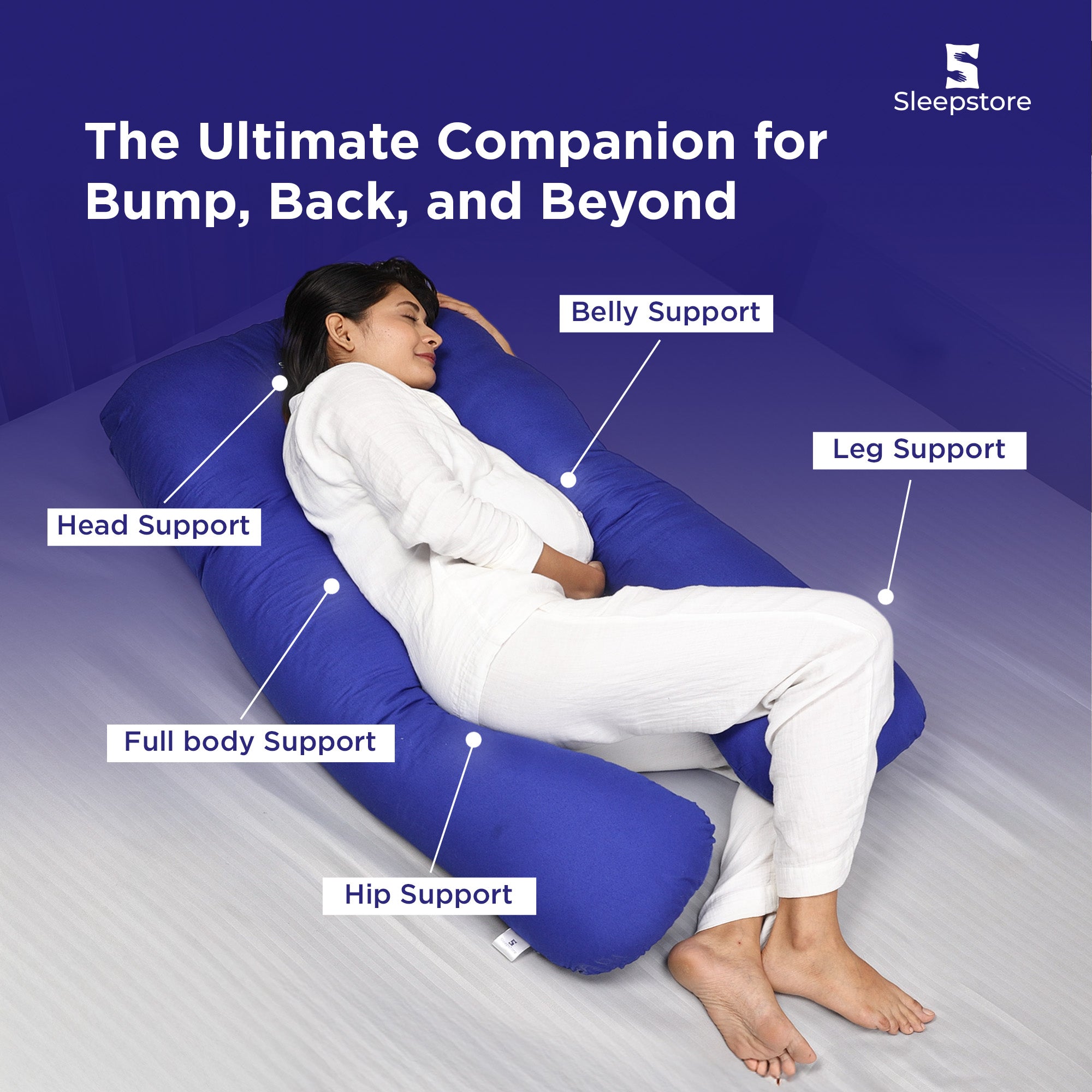 Woman using a blue U-shaped body pillow providing head, belly, hip, and leg support.