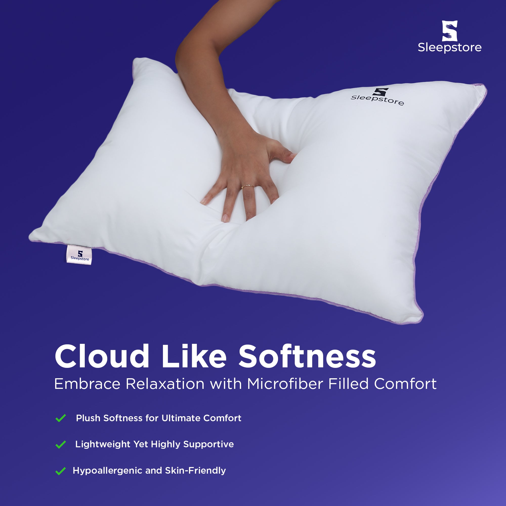 Hand pressing a fluffy white Sleepstore pillow showing cloud-like softness and comfort.