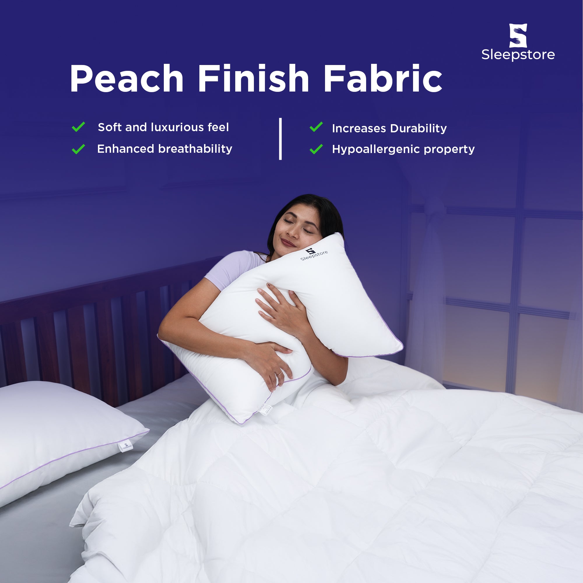 Woman hugging a Sleepstore peach finish pillow while sitting on a cozy white bed