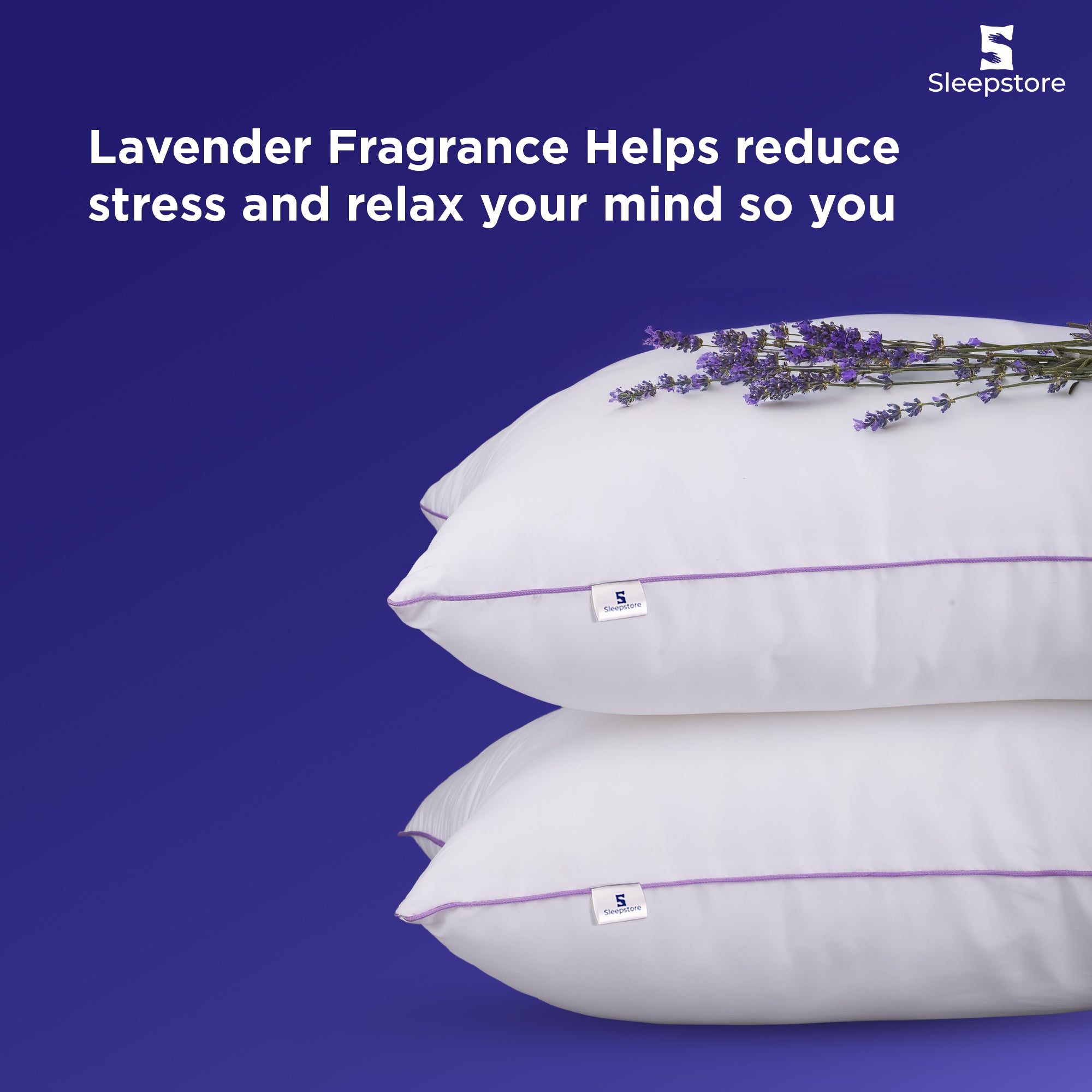 Two stacked Sleepstore lavender pillows with fresh lavender flowers on top.